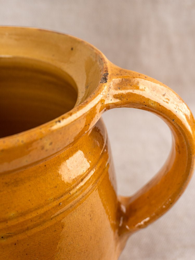 Antique French Savoyard ceramic pitcher with hand-painted floral details and warm yellow ochre glaze.