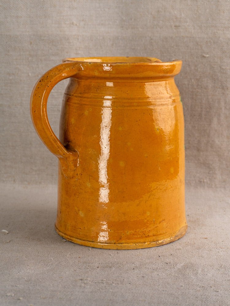 Antique French Savoyard pitcher with yellow ochre glaze, hand painted floral details, single handle.