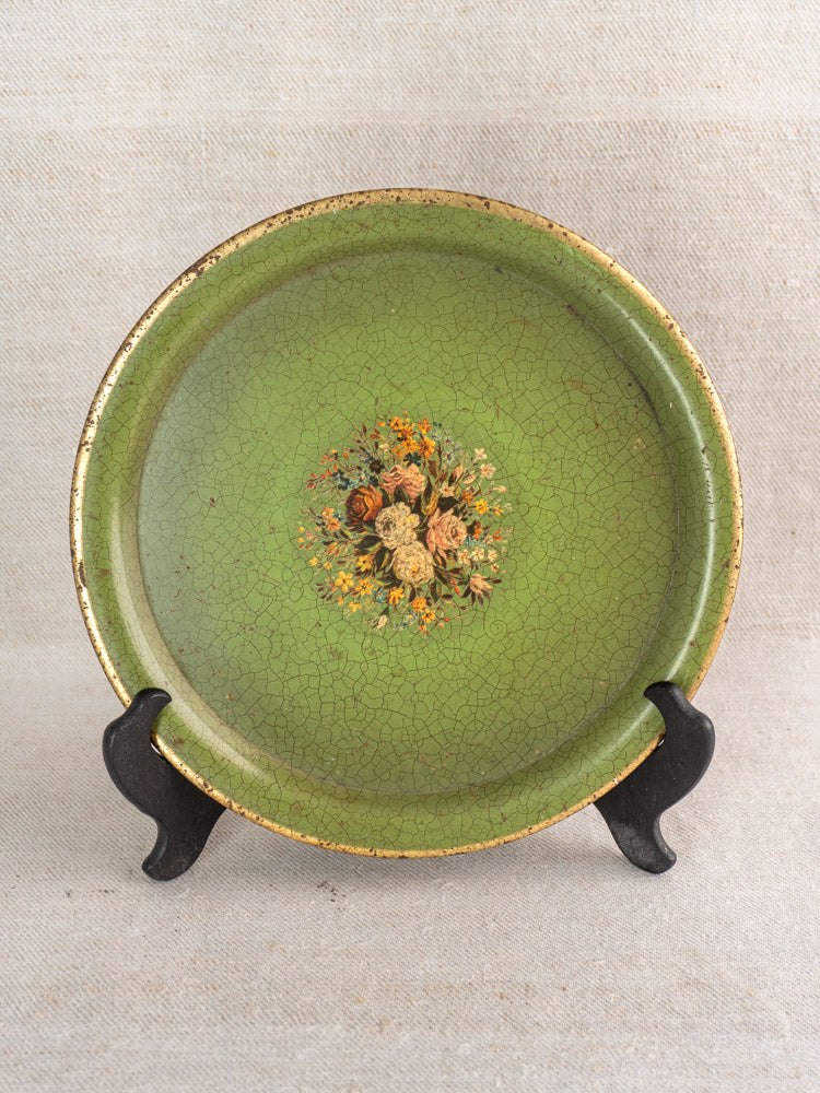 Antique French painted tôle tray with green crackled finish, gold rim, floral bouquet, on black stand.