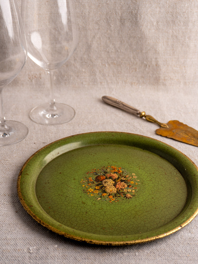Antique French painted tôle tray, c. 1900, with green floral design on beige cloth, flanked by wine glasses and brass cake server.