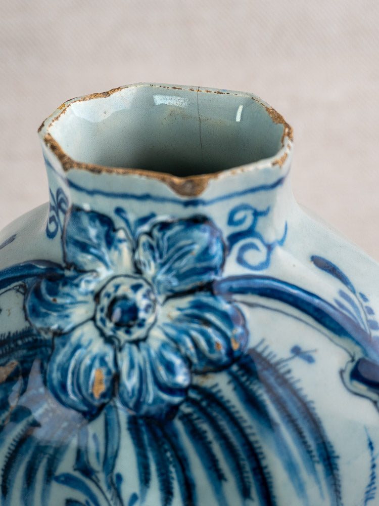 Antique Dutch Delft vase pair, c.1700, with blue and white floral motifs and a chipped rim; softly blurred background.