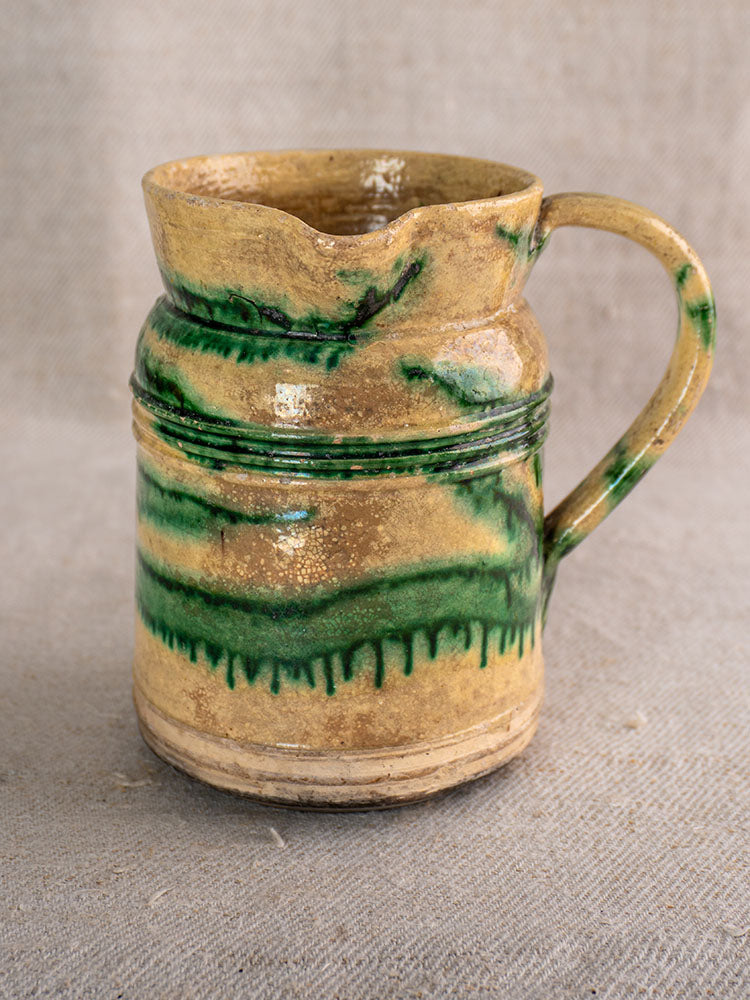 Pair of French antique Jaspé pitchers by Dieulefit with green glaze, wide openings, curved handles on linen cloth.