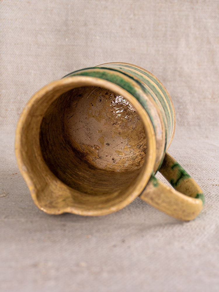 Pair of antique French Jaspé pitchers with green glaze from Dieulefit, worn interiors, small spouts, visible handles.
