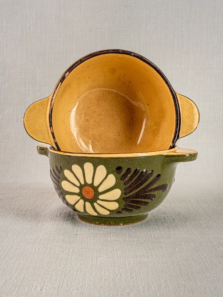 Pair of vintage French Savoyard green glazed bowls with white daisy motif and eared handles, stacked against neutral background.