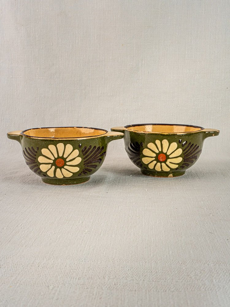 Pair of small green-glazed French bowls with handles, each featuring a large white daisy motif.