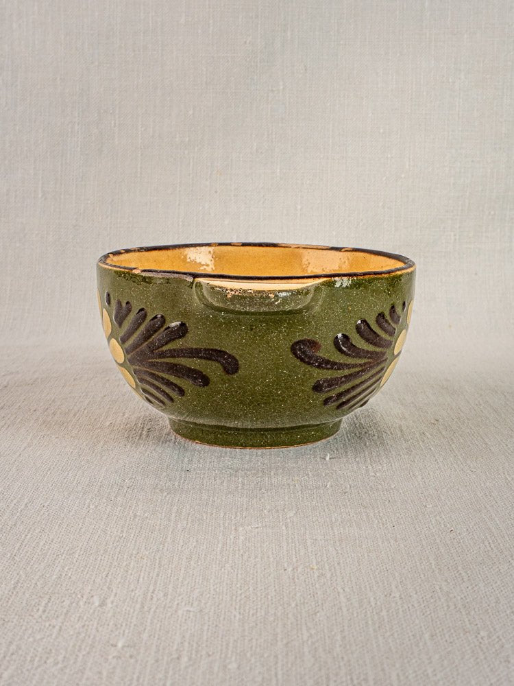 Pair of vintage French Savoyard green-glazed handled bowls with tan interior and brown floral motifs, shown on a light textured background.