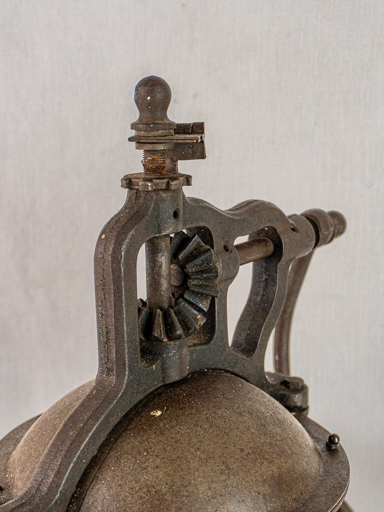 Antique French cast iron Peugeot Frères coffee mill, circa 1900, with weathered texture and visible gears.