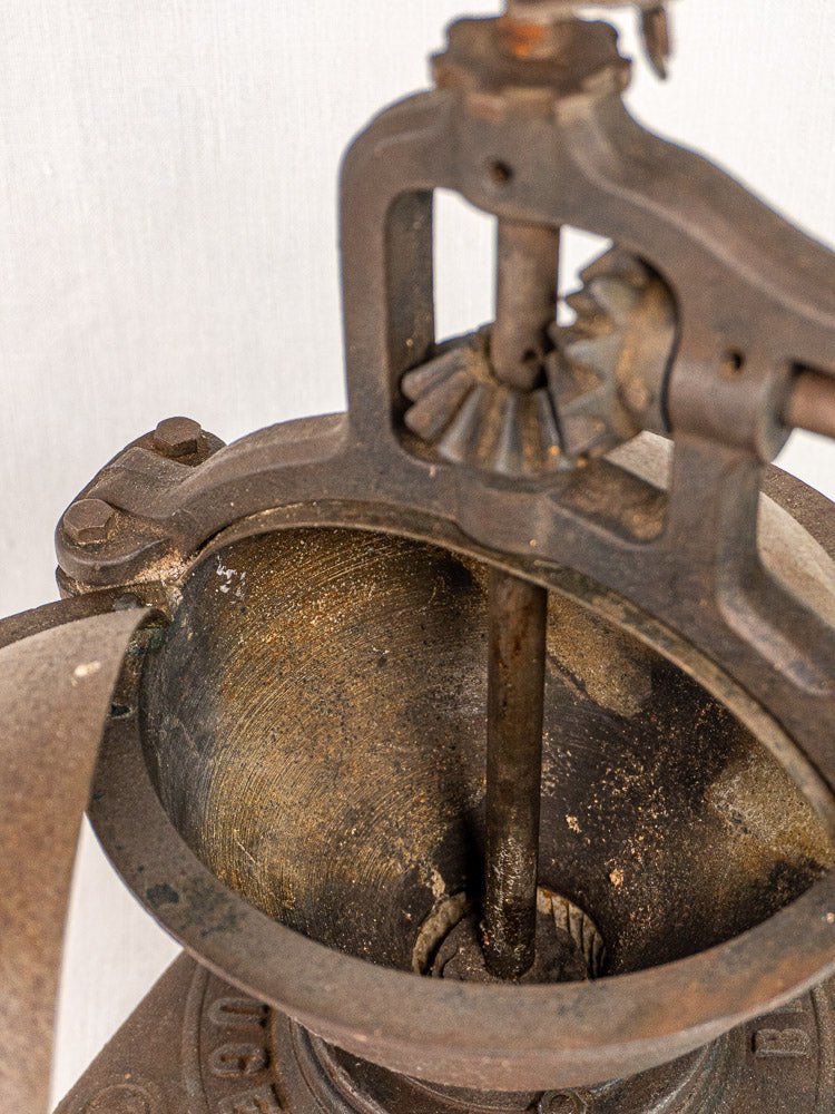 Antique French Peugeot Frères cast iron coffee mill top with exposed grinding mechanism and textured interior.