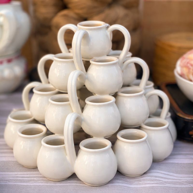 White glazed pichon uzes tulip vase at a French brocante with other items in the background