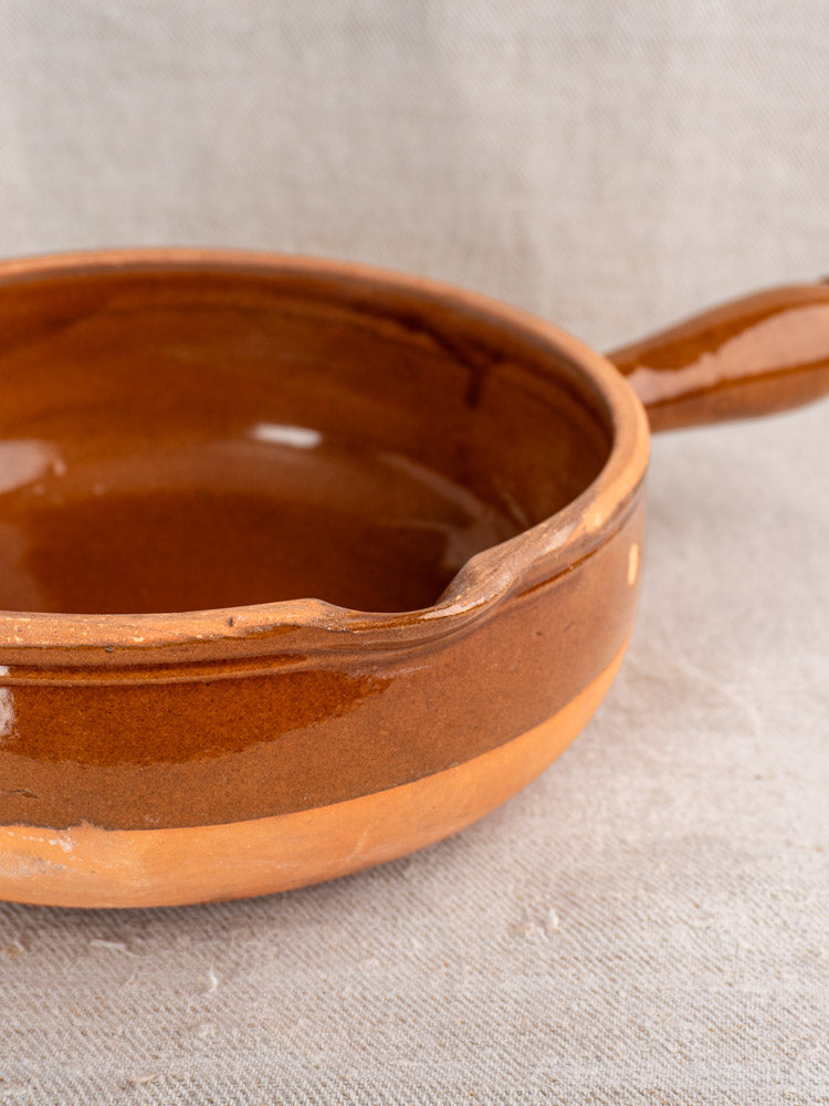 Mid-century French terracotta poêlon pan with hollow handle, glossy interior, and matte lower half in Provençal style.