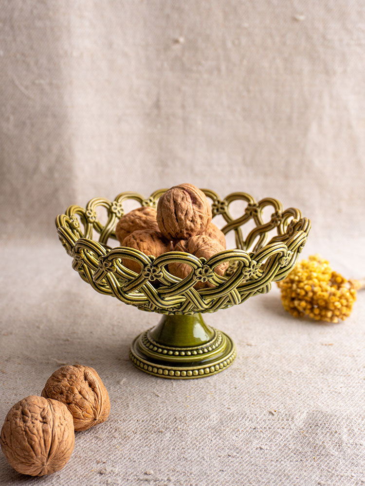 Antique French Pichon Uzès green compote with openwork pedestal, walnuts inside, yellow dried flowers in background.