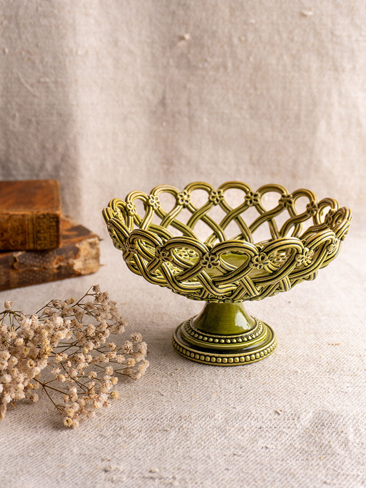 Antique French Pichon Uzès olive green compote with openwork design, styled with vintage books and dried white flowers.