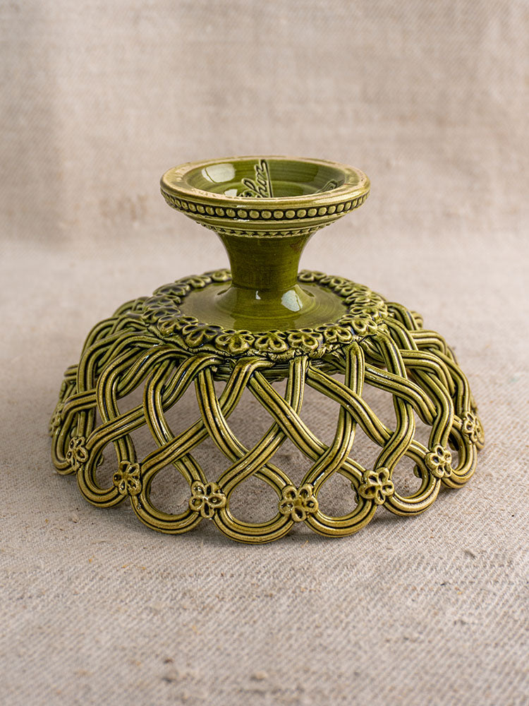 Antique French Pichon Uzès olive green compote with openwork lattice and floral pedestal set on textured beige fabric.