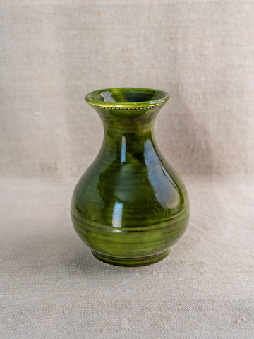 Vintage French Pichon Uzès vase, glossy green glazed earthenware, rounded body and narrow neck on beige textured fabric.