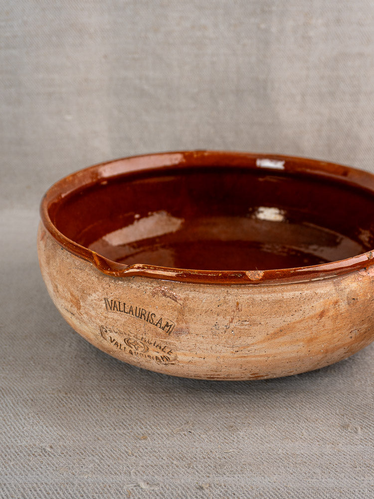Vintage French Vallauris terracotta poêlon with glossy brown interior and beige exterior, stamped “Vallauris AM.”.