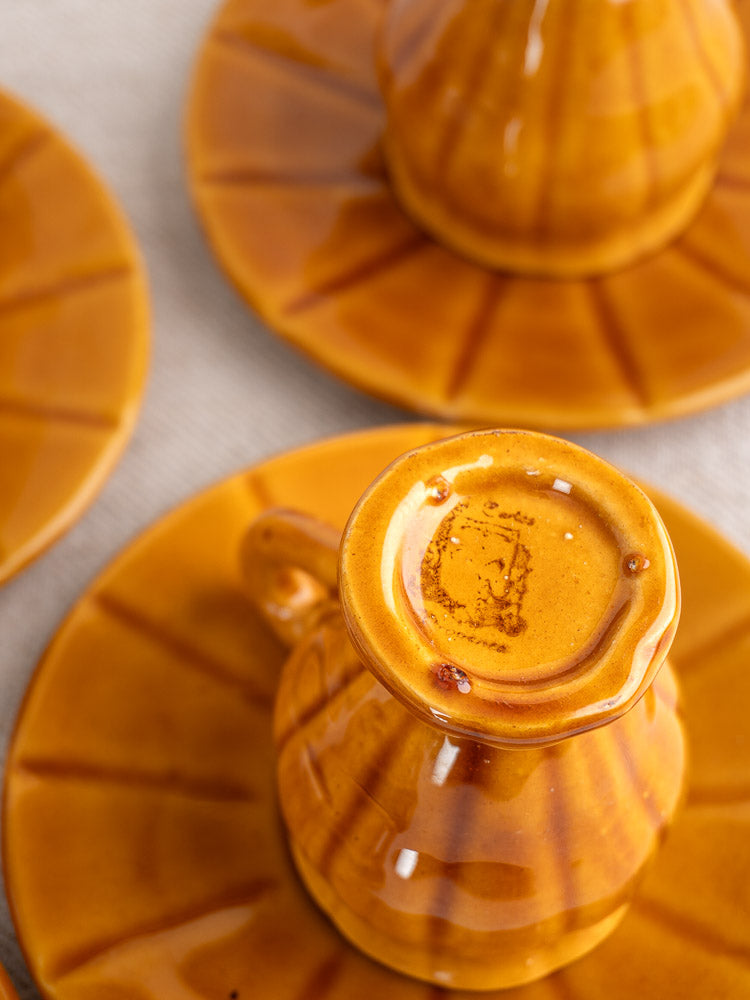 Vintage French honey-glazed earthenware demitasse coffee set with amber-brown ceramic cups and saucers.