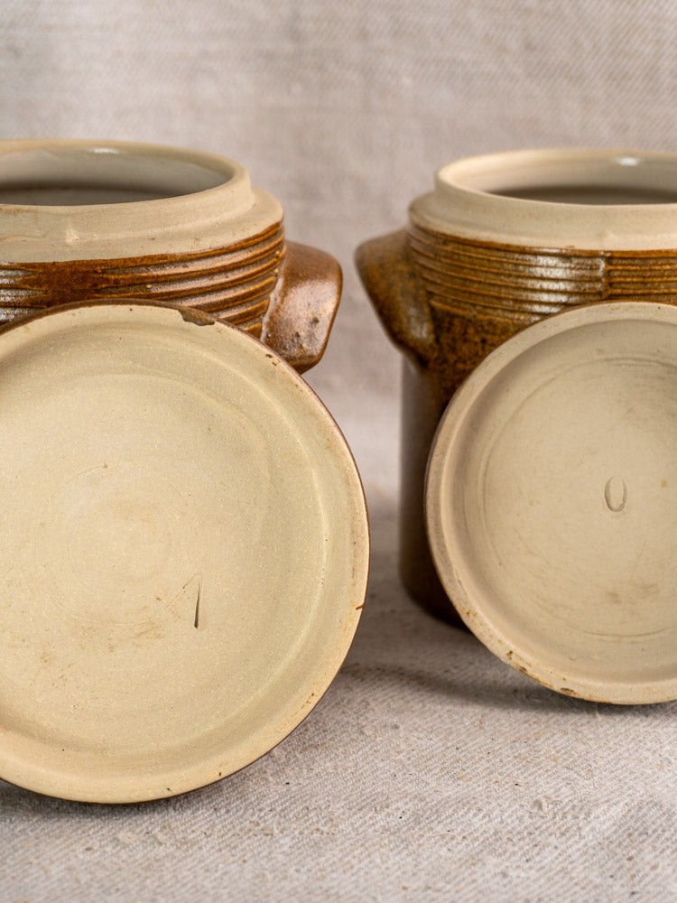 Pair of vintage French Digoin Grespots tan ceramic jars with textured brown exteriors, marked bases.