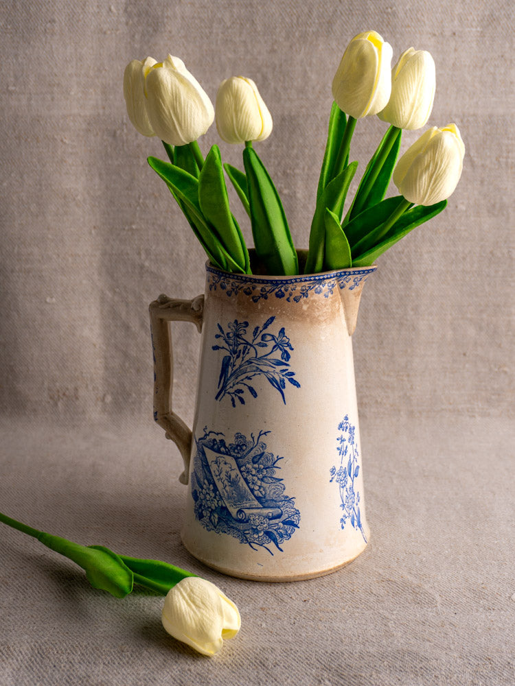 Antique French Fenal Frères Pichet with Pexonne Oiseaux pattern, arranged with white tulips on burlap.