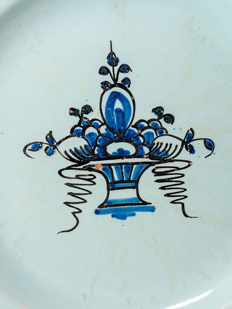 19th century antique French faience plate with hand-painted Rouen-style blue fruit basket on light ground.