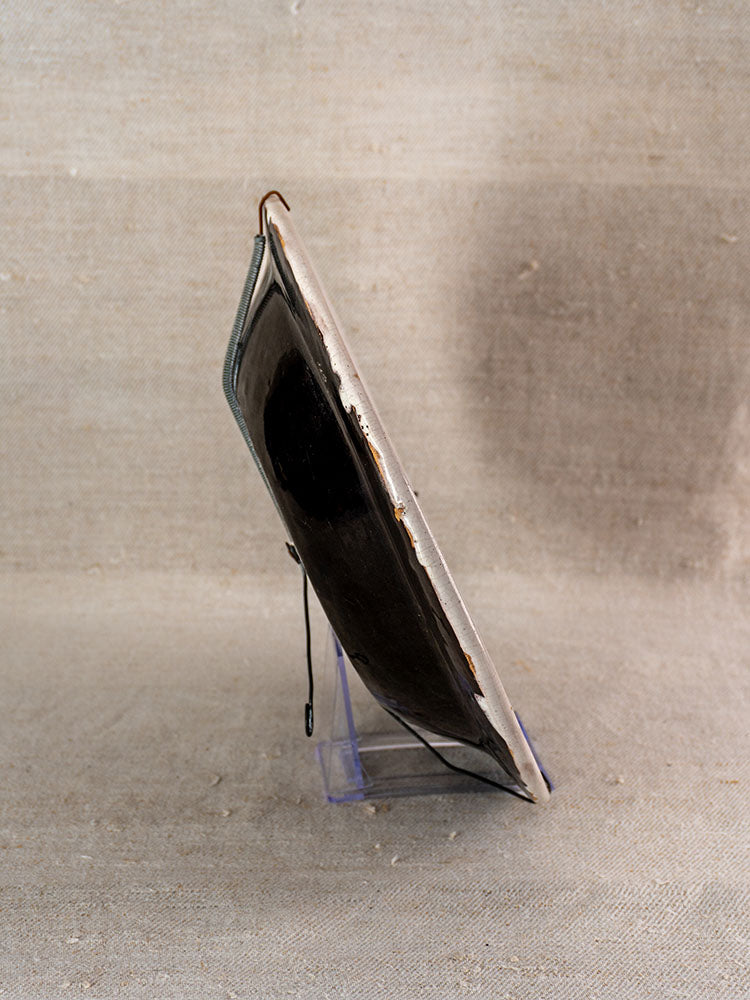Antique French Cul Noir faience charger with Panier Fleuri, dark center, light rim on clear stand, late 18th century.
