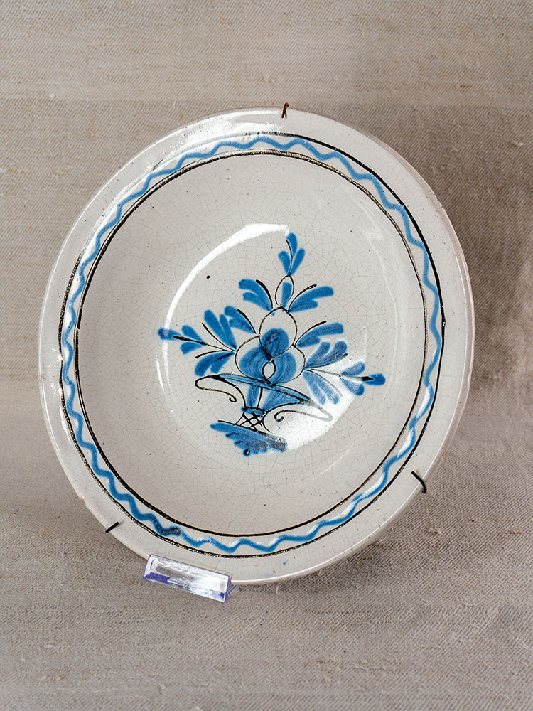 Antique French Cul Noir faience charger, late 18th century, hand-painted blue florals and borders on neutral textured surface.