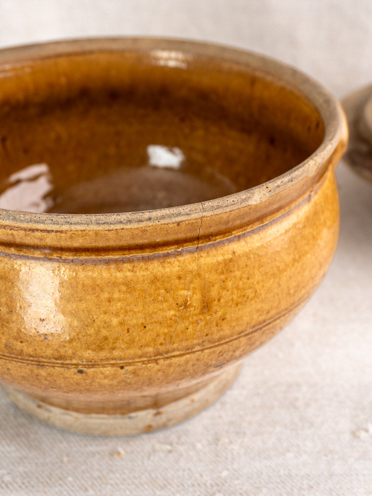 Antique French grès lidded stoneware pot with glossy honey glaze and visible side crack.