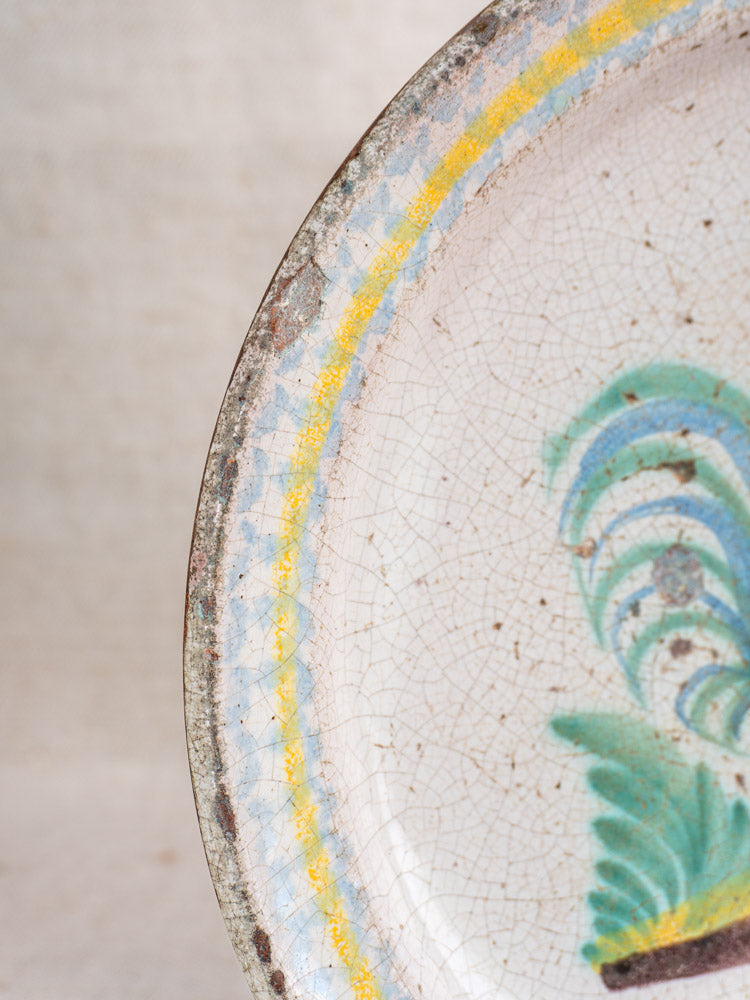 Antique French faience plate edge with crackled glaze, hand-painted rooster, yellow-blue border, feather motif.