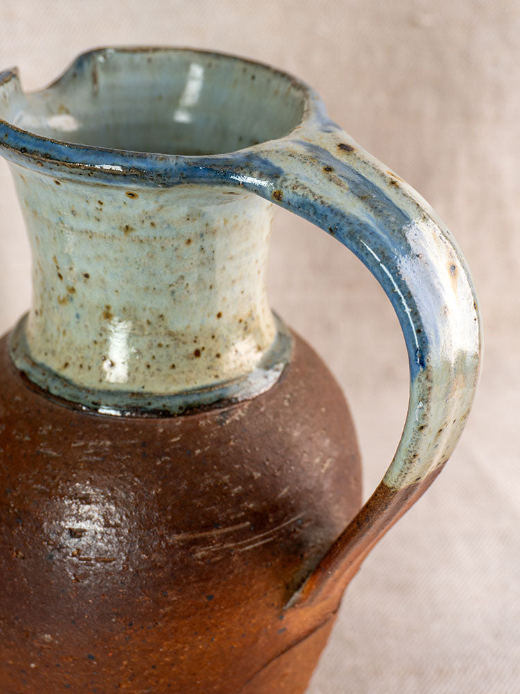 Antique French La Borne stoneware pitcher with blue ash celadon glaze and brown textured body.