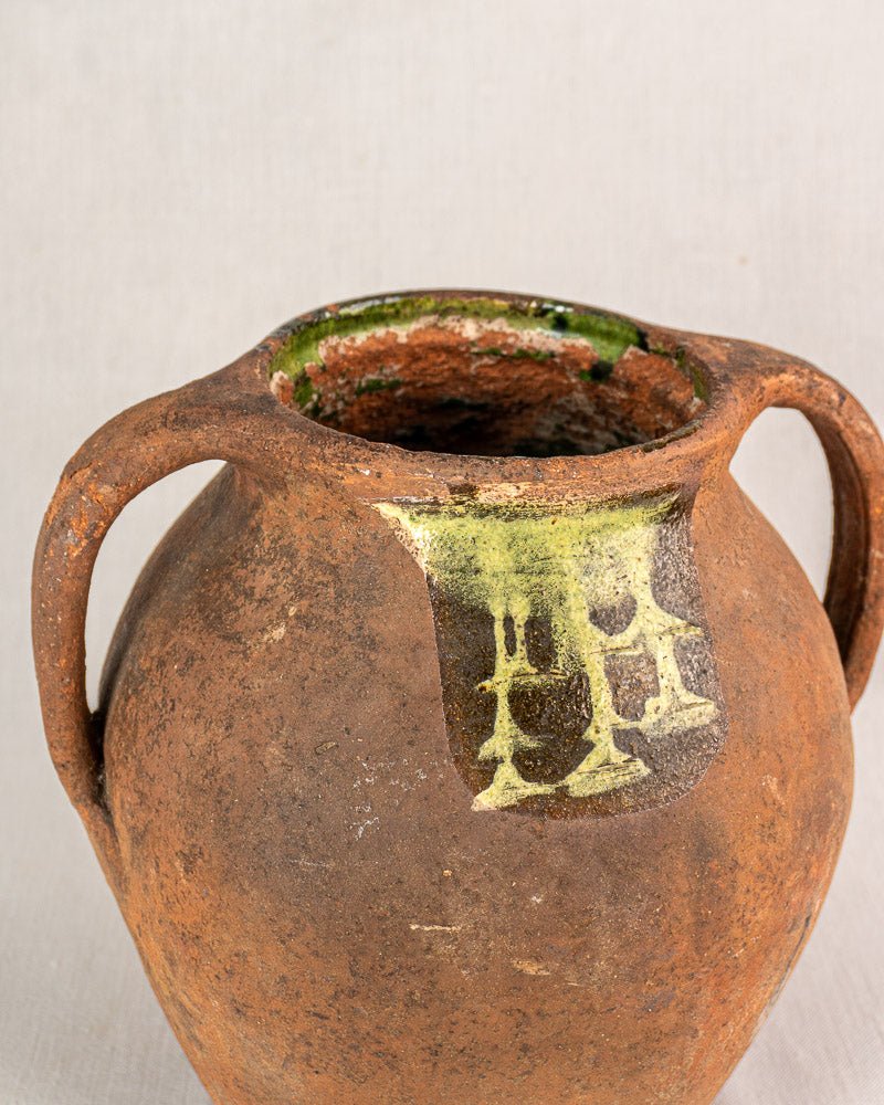 Antique French vinaigrier in brown glazed terracotta with two handles and greenish-yellow rim accents.