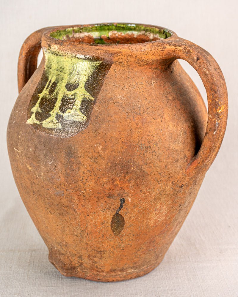 Antique French terracotta vinaigrier with dual handles, green-glazed rim, and aged patina.
