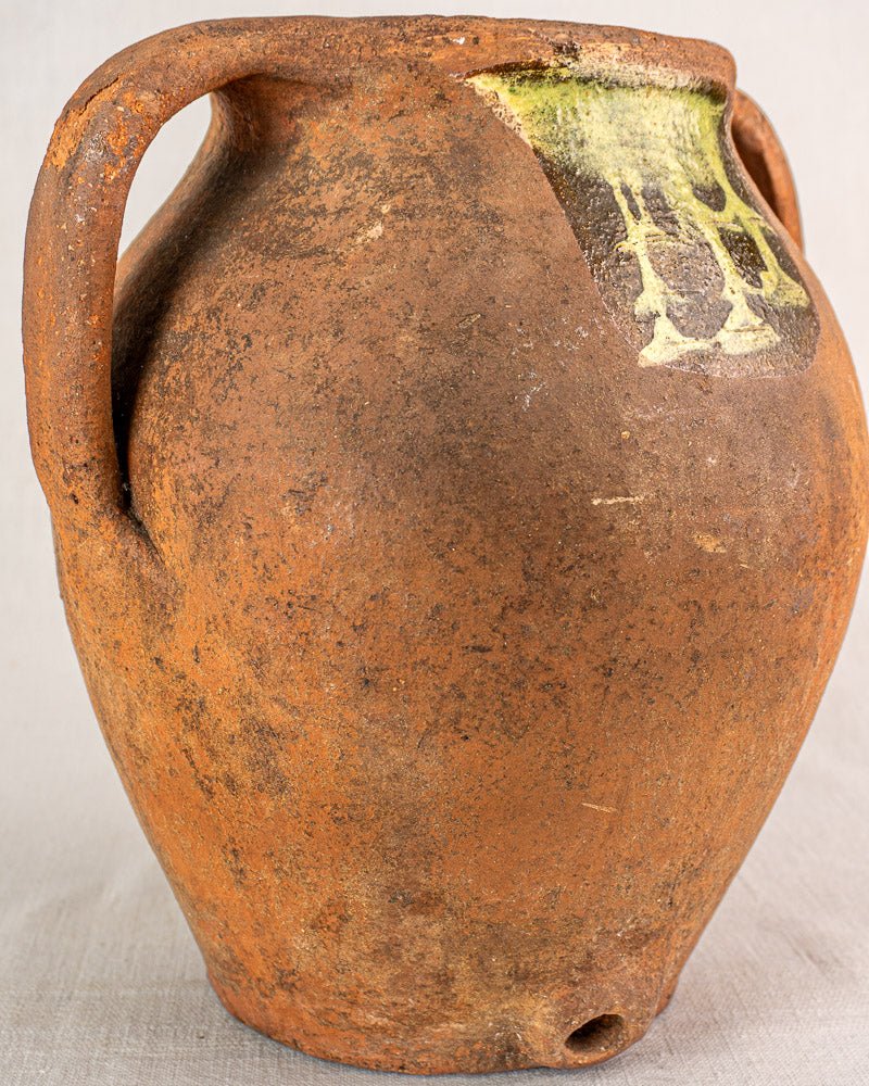 Antique French glazed terracotta vinaigrier with yellow-green rim, two handles, textured surface, c. 1880–1900.