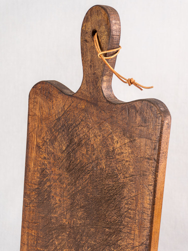Antique French cutting board with paddle handle, late 19th century, knife marks showcasing vintage farmhouse character.