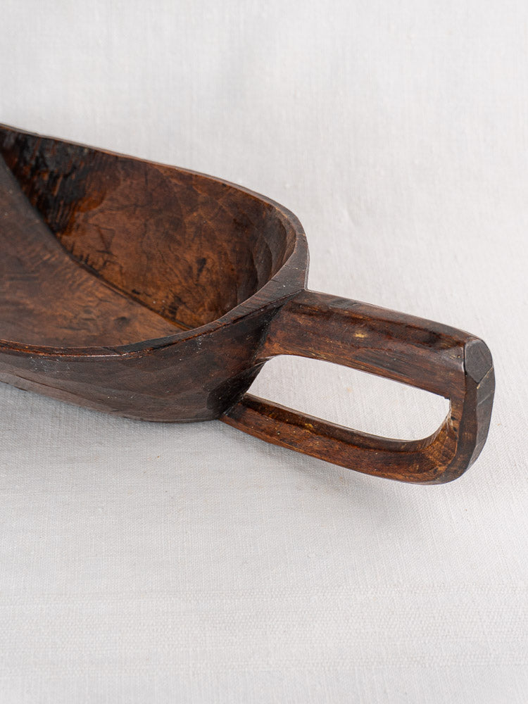 Antique French 19th-century wooden grain scoop with rectangular handle on a light, textured background.