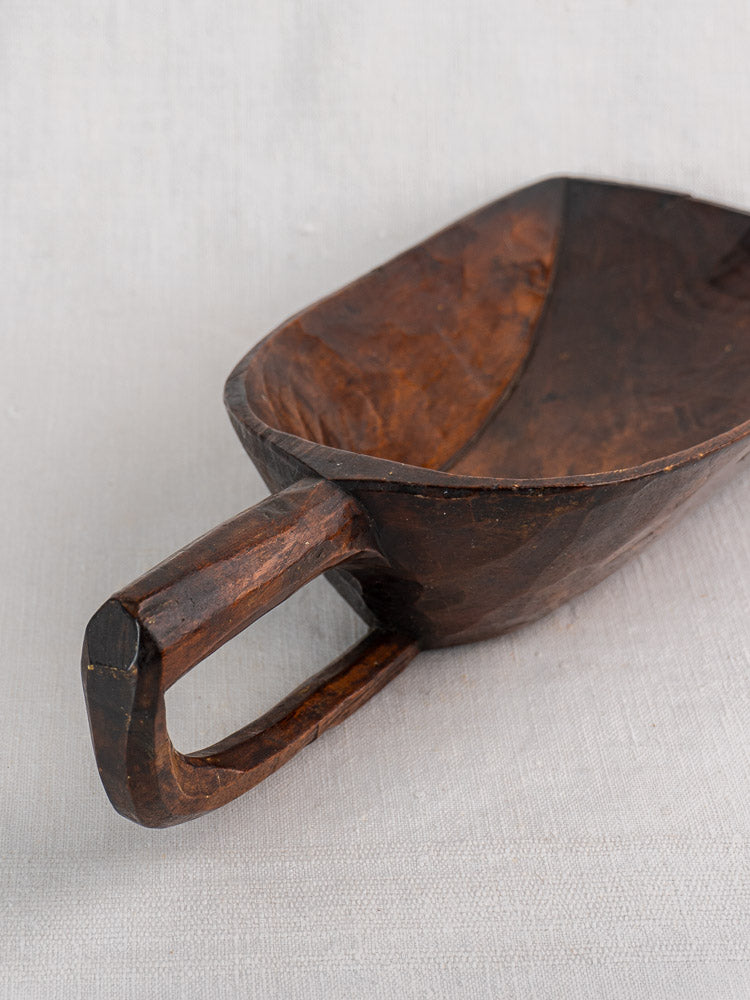 Antique French wooden grain scoop, 19th century hand carved, rustic finish, displayed on light fabric background.