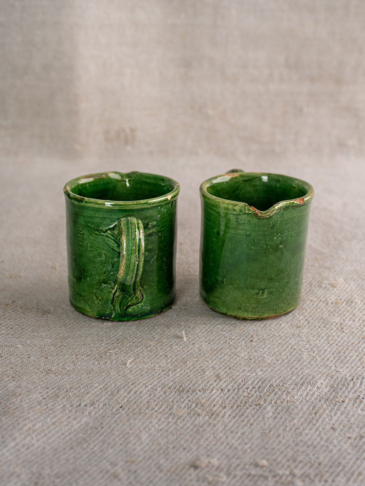 French green glazed ceramic pieces with glossy finish and rustic Provençal style, displayed on beige fabric, from 8-piece set.