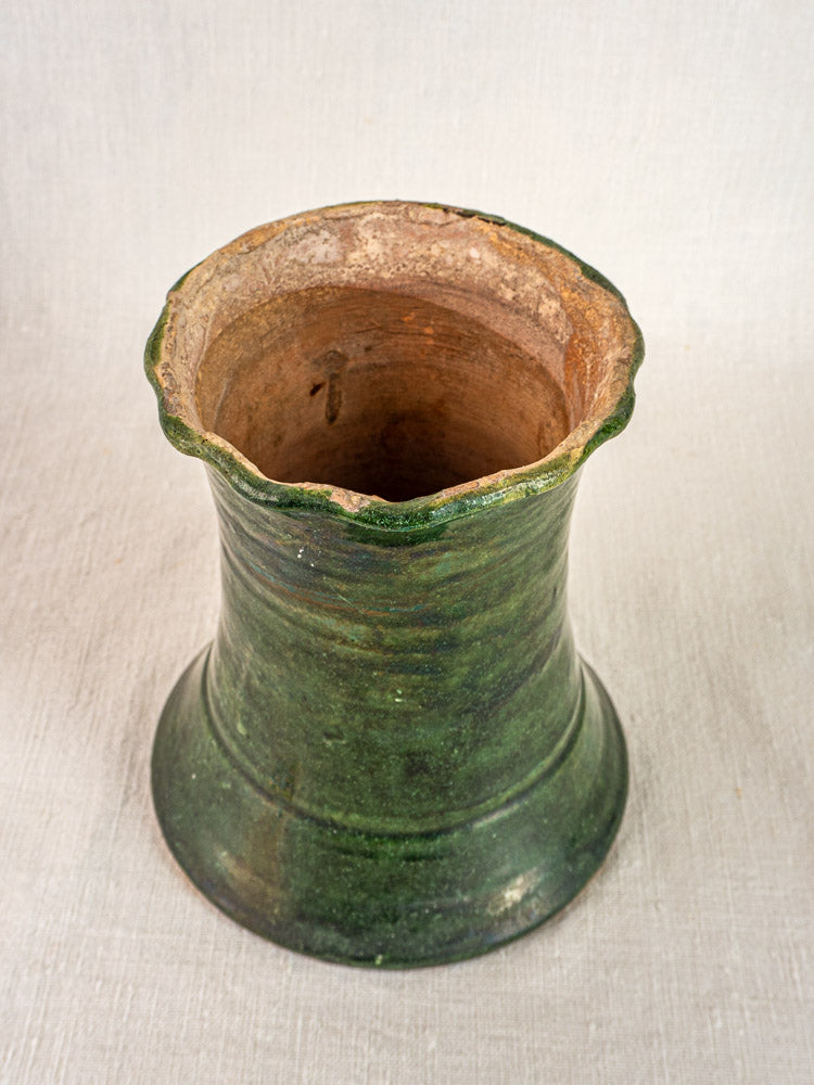 Overhead view of antique French green glazed terracotta vase with wide mouth and wavy rim.