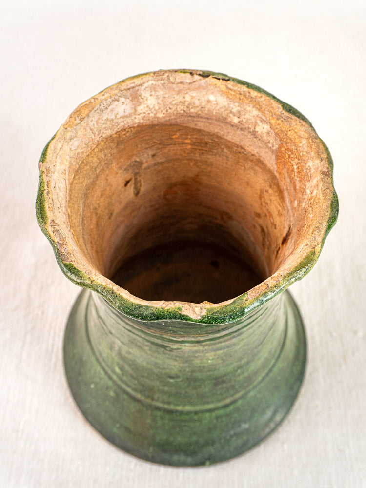 Antique French green glazed terracotta vase with wide opening, flared rim, and textured surface on light background.