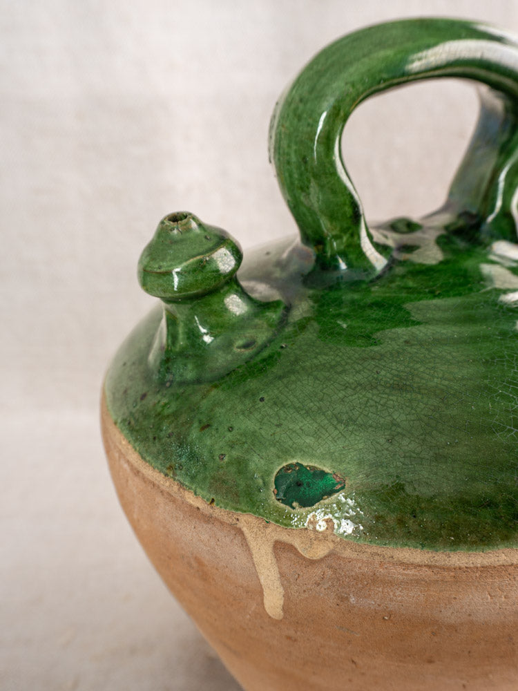 Antique French gargoulette with emerald green glazed lid, knob, handle, chipped rim, and natural clay base.