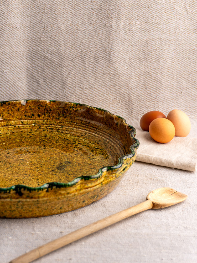 Vintage French signed JANY Studio earthenware tarte dish, wavy edge, mottled yellow glaze, green speckles.