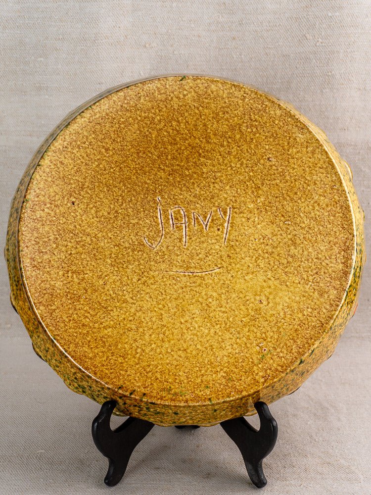 Vintage French JANY Studio yellow ceramic tarte dish on black stand, signed underside, neutral woven backdrop.