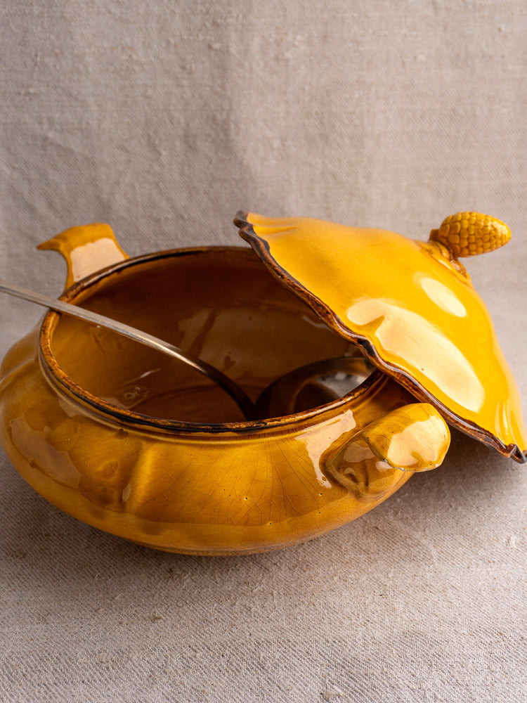 Vintage French Haute Provence yellow faience tureen with pine cone finial, partial lid, and metal ladle.