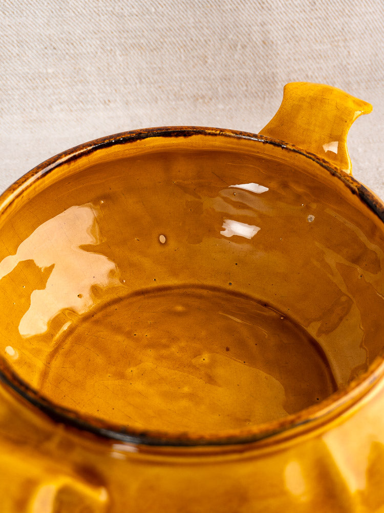 Glazed Vintage French Haute Provence faience tureen in yellow with pine cone finial, light background.