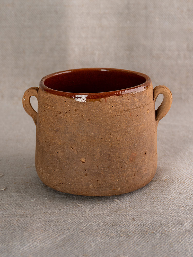 Antique French confit pot with rustic brown glaze, two handles, and glossy interior, classic 19th-century country pottery.