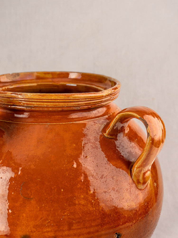 Antique French cruche, late 19th-early 20th century glazed earthenware jug with honey-brown finish and curved handle.