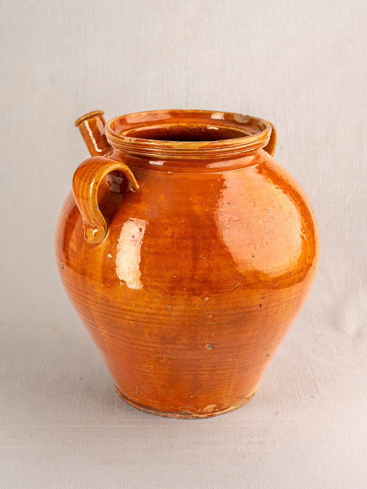 Late 19th-century French glazed earthenware cruche with two handles, small spout, honey-brown finish on textured surface.