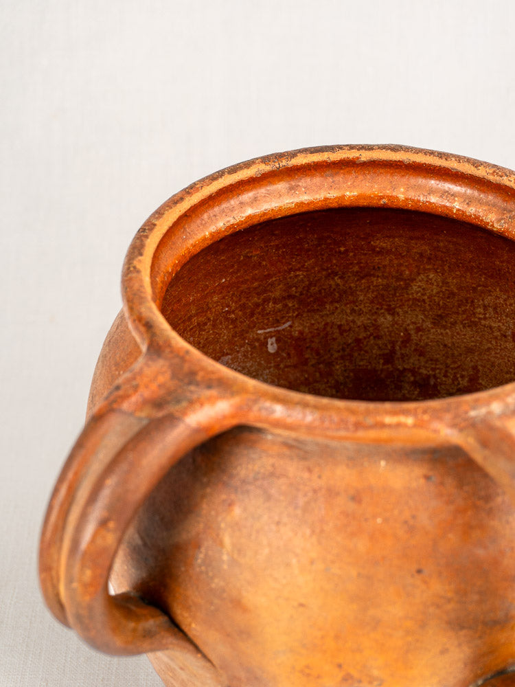 Antique French two-handle earthenware jug, 19th century, glazed and weathered, set against a plain white background.