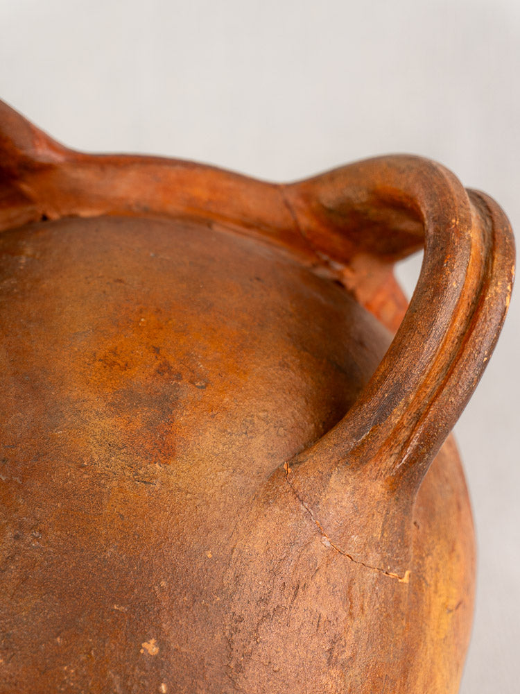 Antique French two-handle glazed earthenware jug with weathered brown finish, Southern France, 19th century, on neutral background.