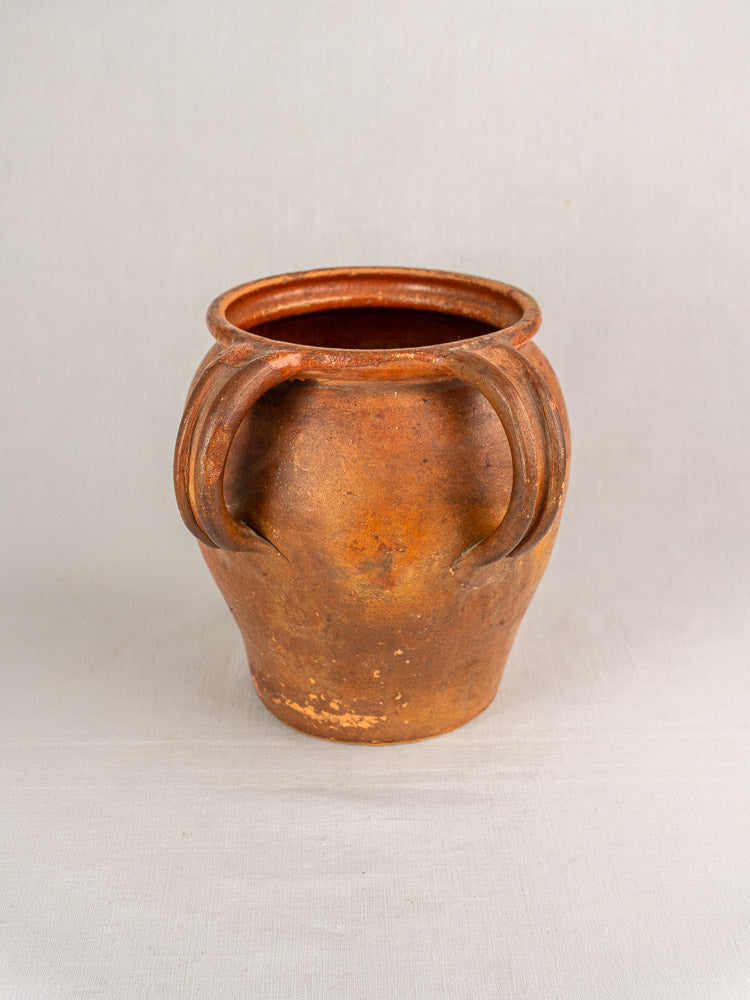 19th-century French glazed earthenware jug with rustic brown finish, rounded body, and two curved handles on light background.
