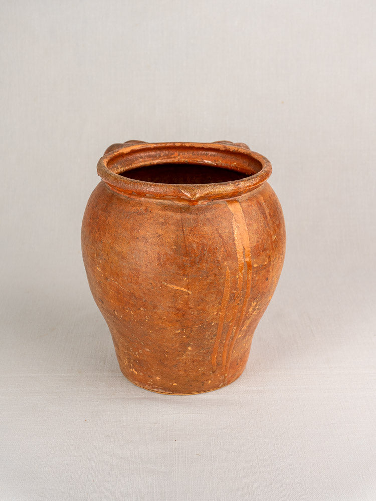 Antique 19th c. French glazed earthenware two-handle jug with rustic round form, decorative rim ridges; plain light background.