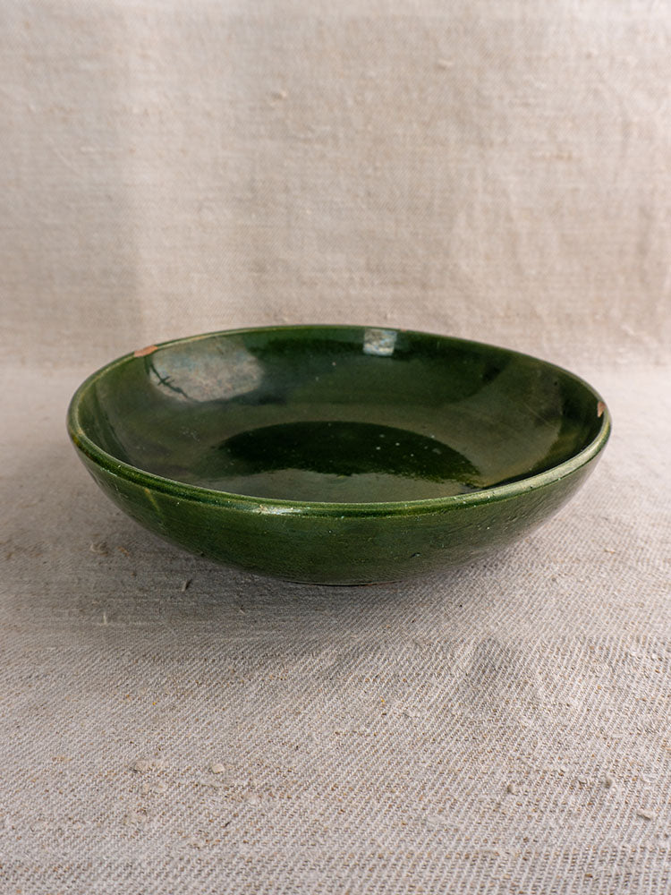 Pair of vintage French Provençal green glazed ceramic serving bowls displayed on textured beige fabric.